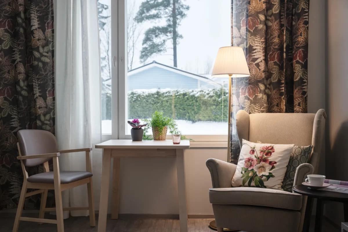 Esperi-kodin viihtyisä asukashuone, josta avautuu maisema pihalle.