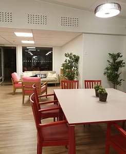 Oleskelu/ruokailutila, jossa pöytiä ja tuoleja.