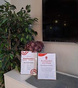Hoivakodin yhteistilan taso, jossa diplomeita ja kunniakirjoja.