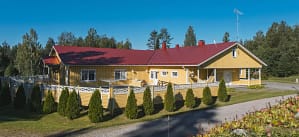 Esperi Koti Elmerin julkisivu ja piha-aluetta kesäisissä maisemissa.