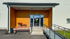 Esperi Hoivakoti Kailinrannan sisäänkäynti, jonka pielessä on kukkia ja sisäänkäynnin edustalla ramppi.