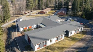 Ilmakuva hoivakodista, rakennuksen muoto ja piha-alue ylhäältä.