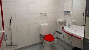 Esteetön kylpyhuone hoivakodissa, wc tukikahvoilla ja apuvälineillä.