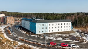 Kodin rakennus sivusta kuvattuna, moderni ja valoisa rakennus metsän laidalla Kangasalla.