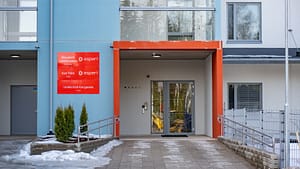 Kodin pääsisäänkäynti, jossa punainen sisäänkäyntikehys ja opastekyltit.