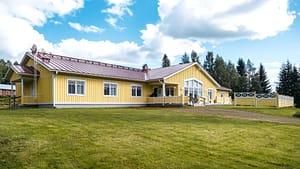 Esperi Koti Elmerin keltainen rakennus ja avara nurmipiha.