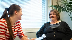 Esperi-kodin ohjaaja ja mielenterveyskuntoutujien kodin asukas juttelevat keskenään ja ohjaaja tekee muistiinpanoja.