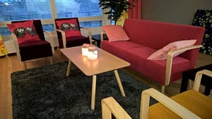 Hoivakodin olohuone hämärän aikaan, pöydällä kynttilä.