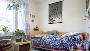 Asukkaan huone, jossa on sänky ja sisustuselementtejä.
