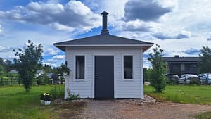 Piharakennus vehreänä kesäpäivänä.