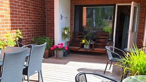 Hoitokodin terassi, jossa kalusteita ja kukkasia.