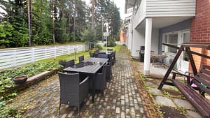 Kivetty kulkuväylä rakennusten välissä, reunoilla istutuksia.