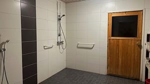 Kylpyhuone, jossa näkyy ovi saunaan.