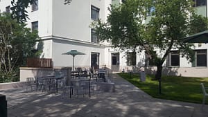 Hoivakodin julkisivu, jossa näkyy puita ja vehreää pihaa edustalla.