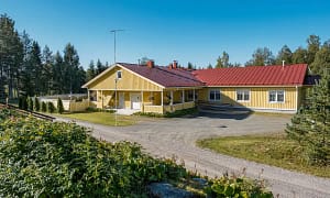 Esperi Koti Elmerin julkisivu ja piha-aluetta kesäisissä maisemissa.