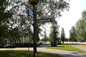 Hoivakodin vehreää ympäristöä, edustalla tienviitta / kyltti.