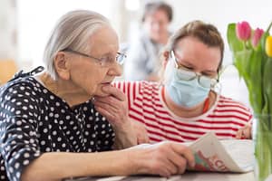 Kaksi ihmistä vierekkäin katsomassa lehteä.