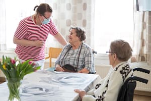 Ihmisiä yhdessä pöydän ympärillä.