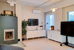 Hoivakodin viihtyisä yhteinen oleskelutila ja televisio.