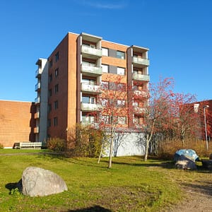 Kuva hoitokodin julkisivusta vehreässä, syksyisessä ympäristössä.