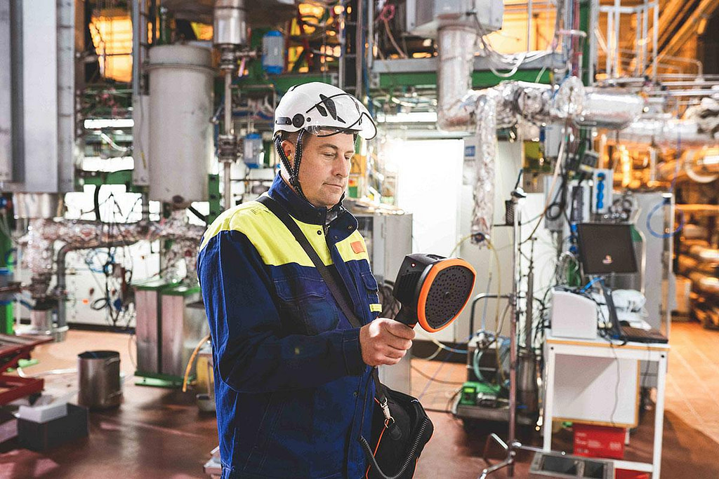 Maintenance man holding and looking down at an ultrasonic leak detector