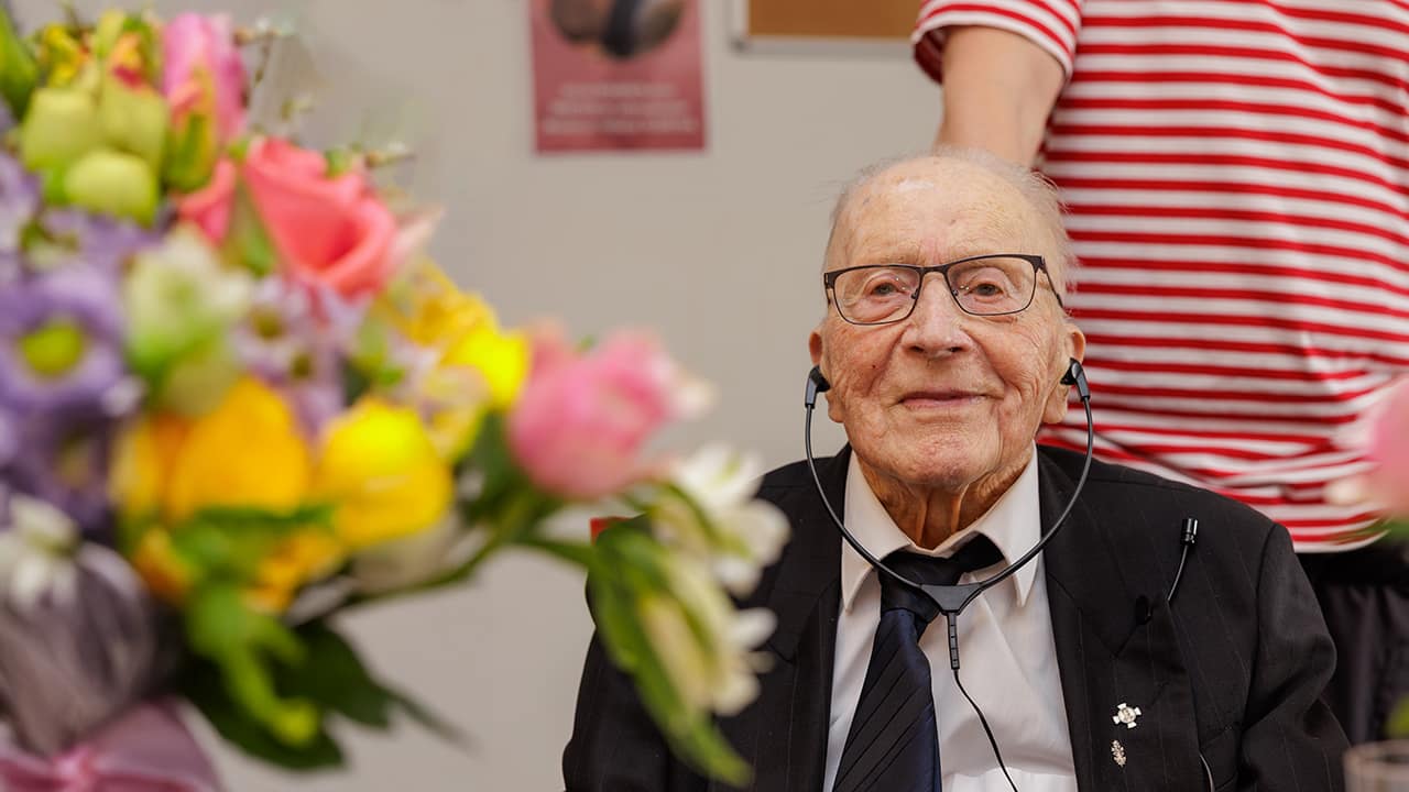 sotaveteraani Veijo Kesäläinen kukkakimpun ja kahvikupin ääressä