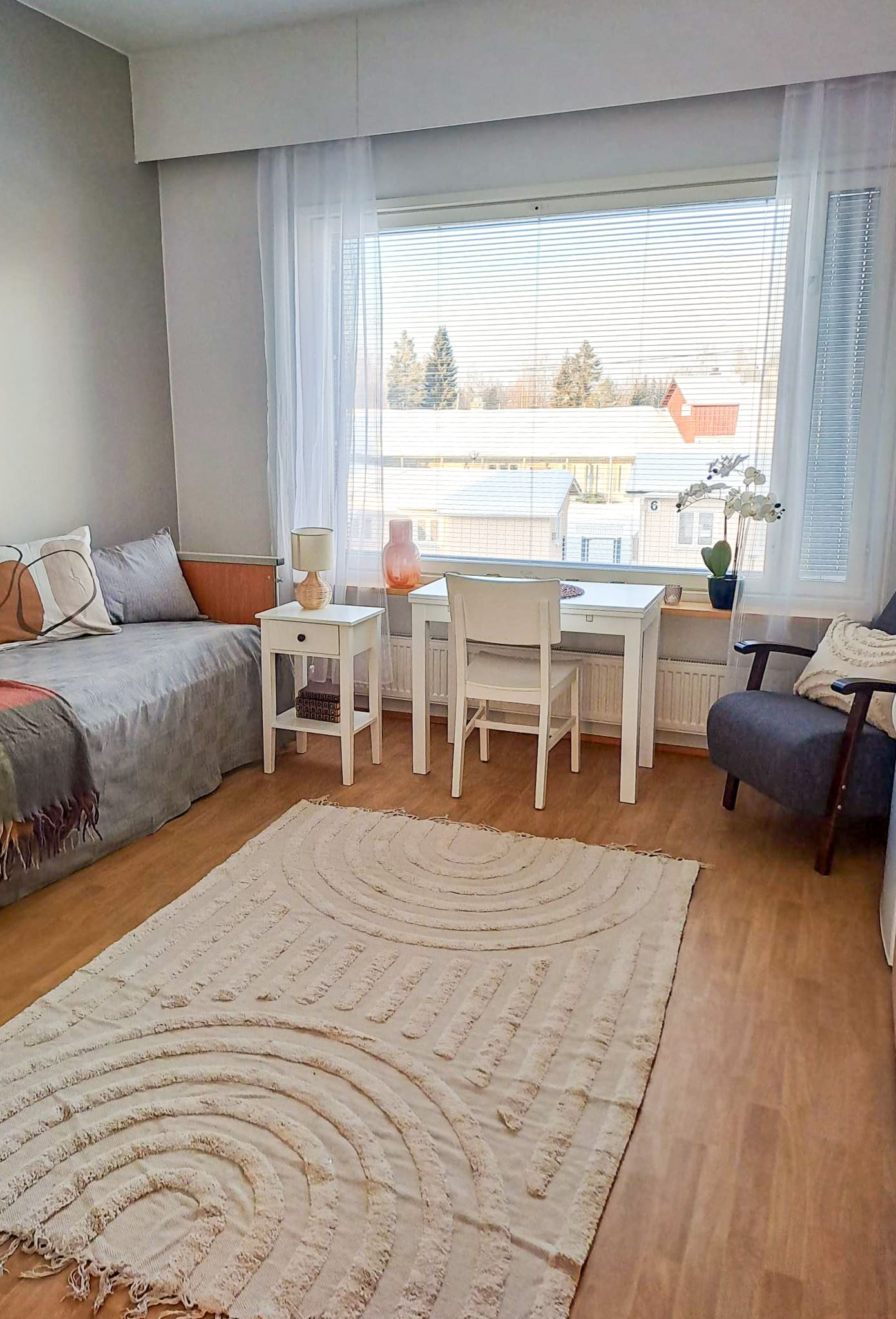 Annabellen asukashuone, jossa sänky, pöytä ikkunan edessä ja nojatuoli.