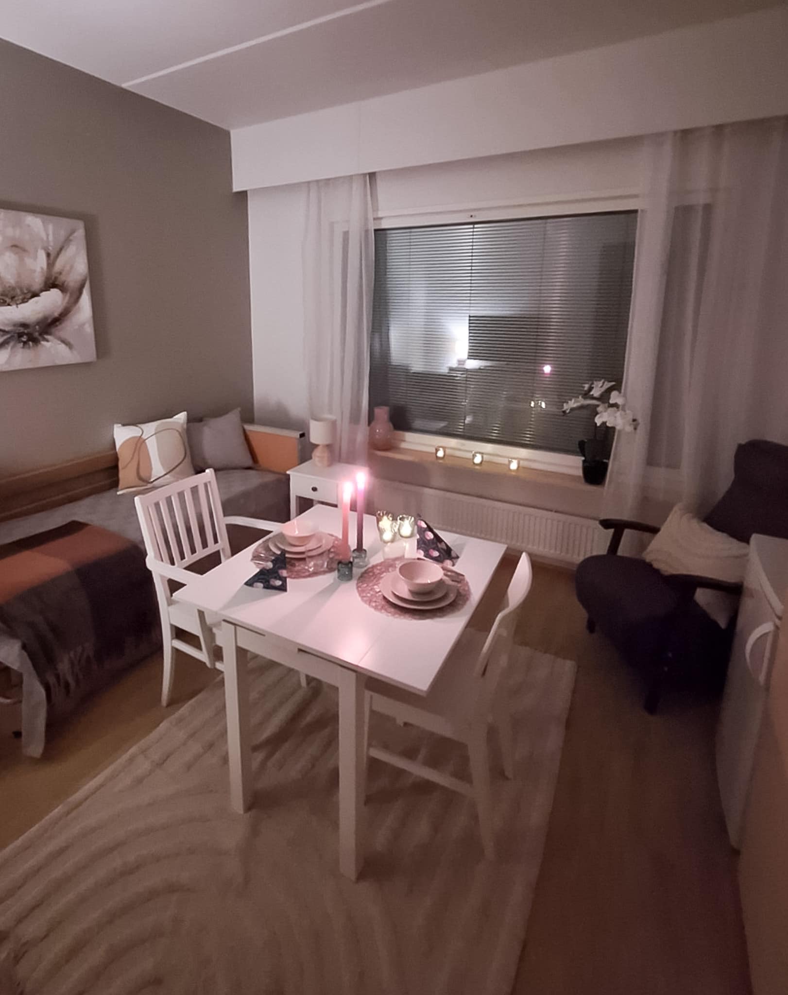 Esperi Hoivakoti Annabellen asukashuone, jossa ruokapöytä kahdelle, nojatuoli ja sänky.