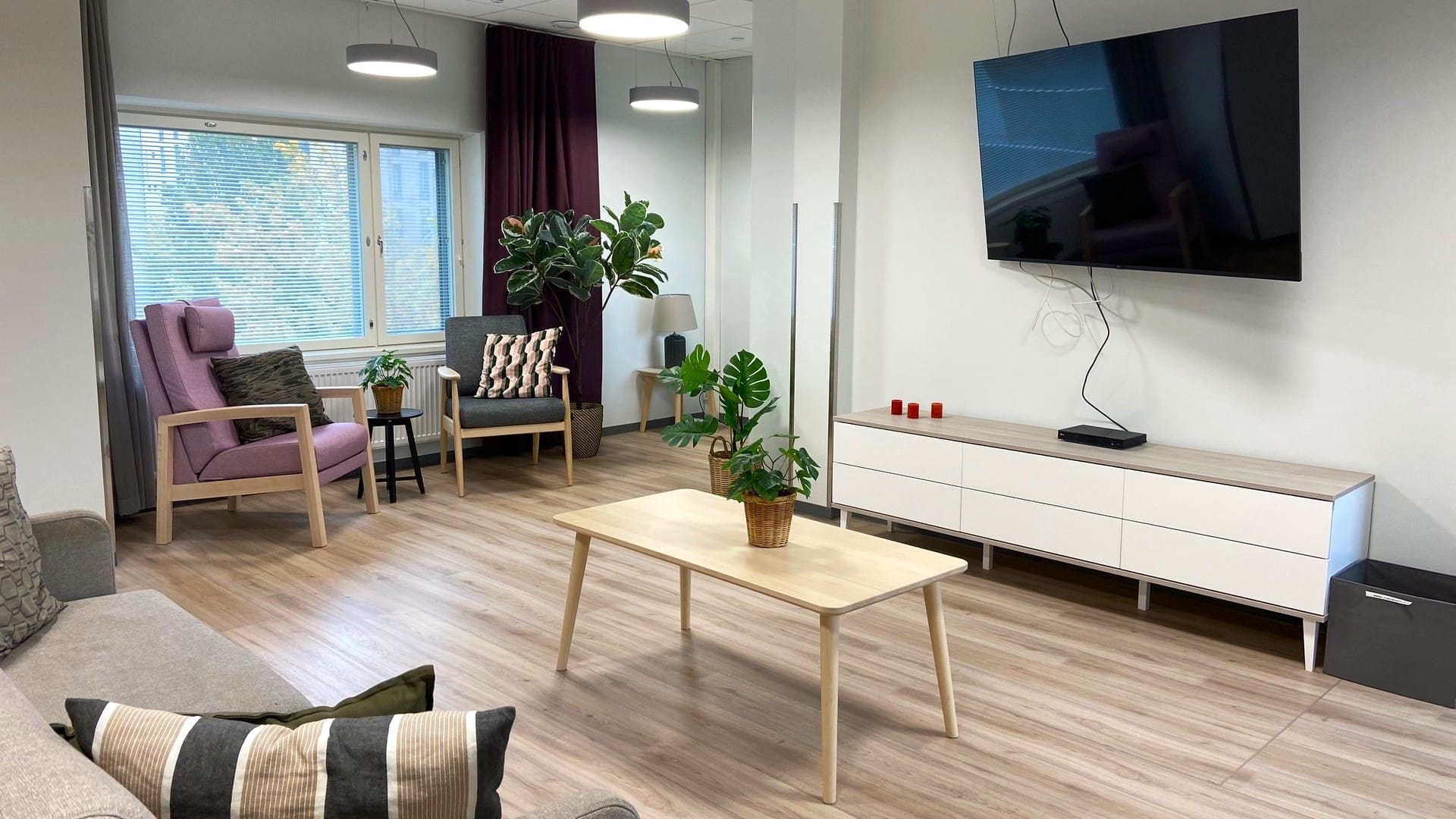 Yhteinen oleskelutila televisioineen ja suurine ikkunoineen