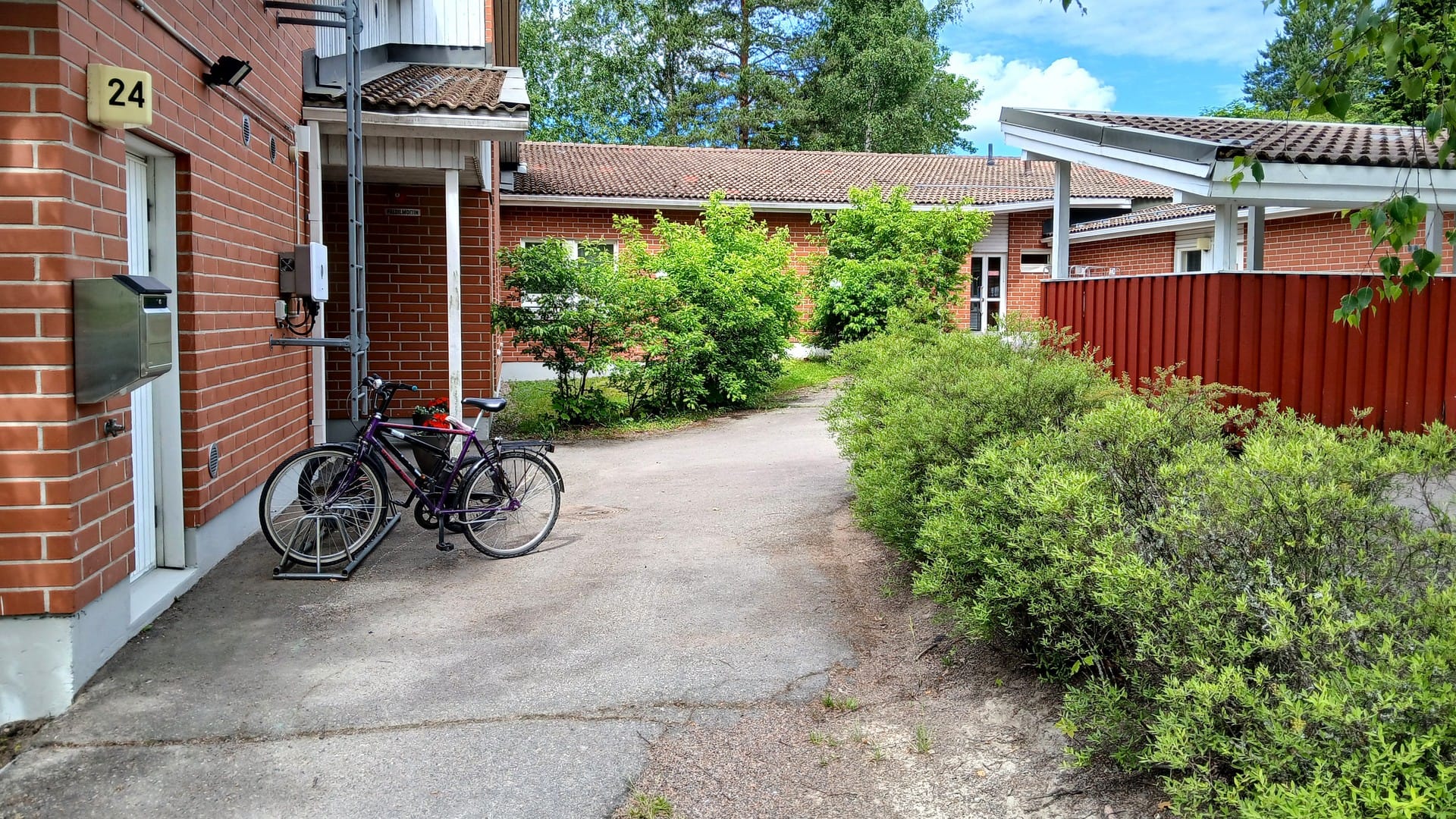 Hoivakoti Käpylän Helmen julkisivu ja vehreä piha-alue terasseineen.