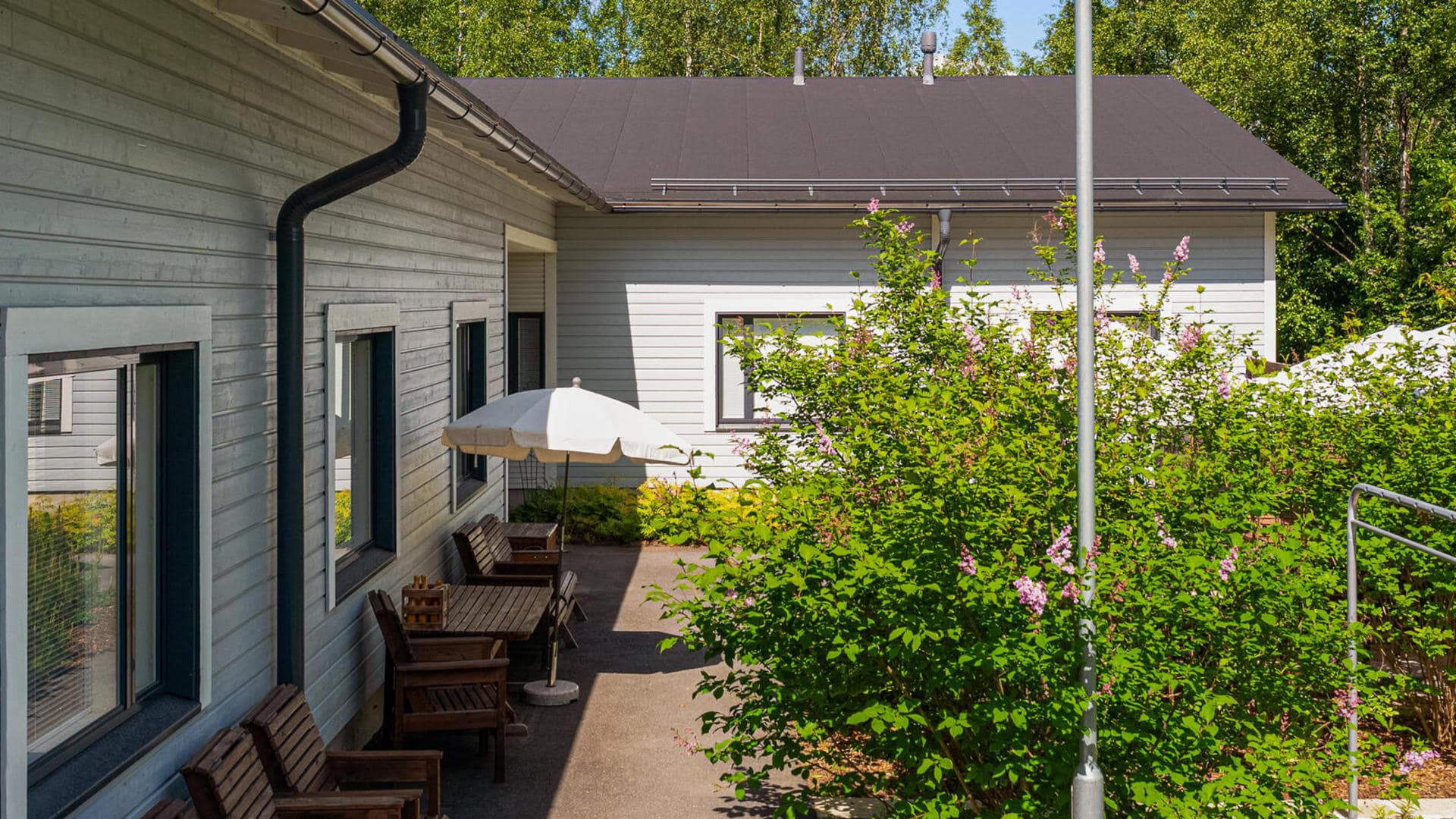 Rakennusten välinen viihtyisä piha-alue istutuksineen.