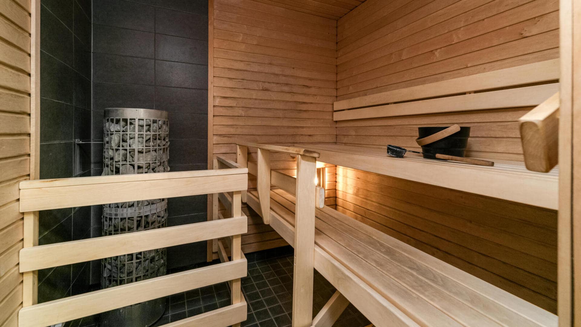 Puupaneloitu sauna lauteineen.