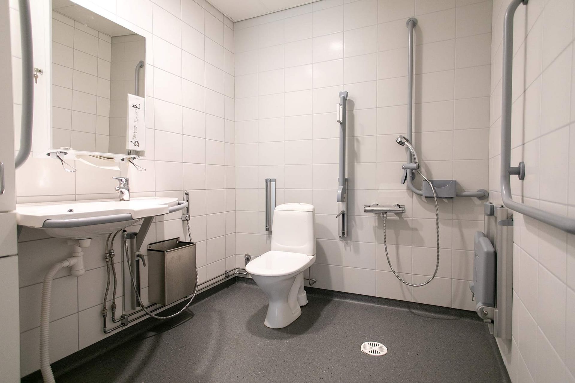 Esteetön kylpyhuone suihkulla ja tukikahvoilla