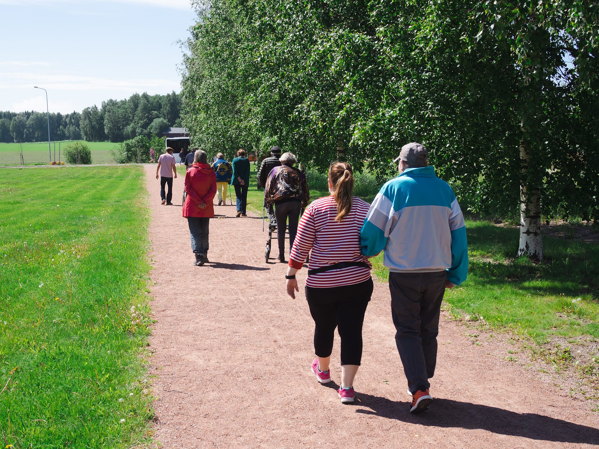 Päivätoimintaryhmä ulkoilemassa vehreässä ympäristössä