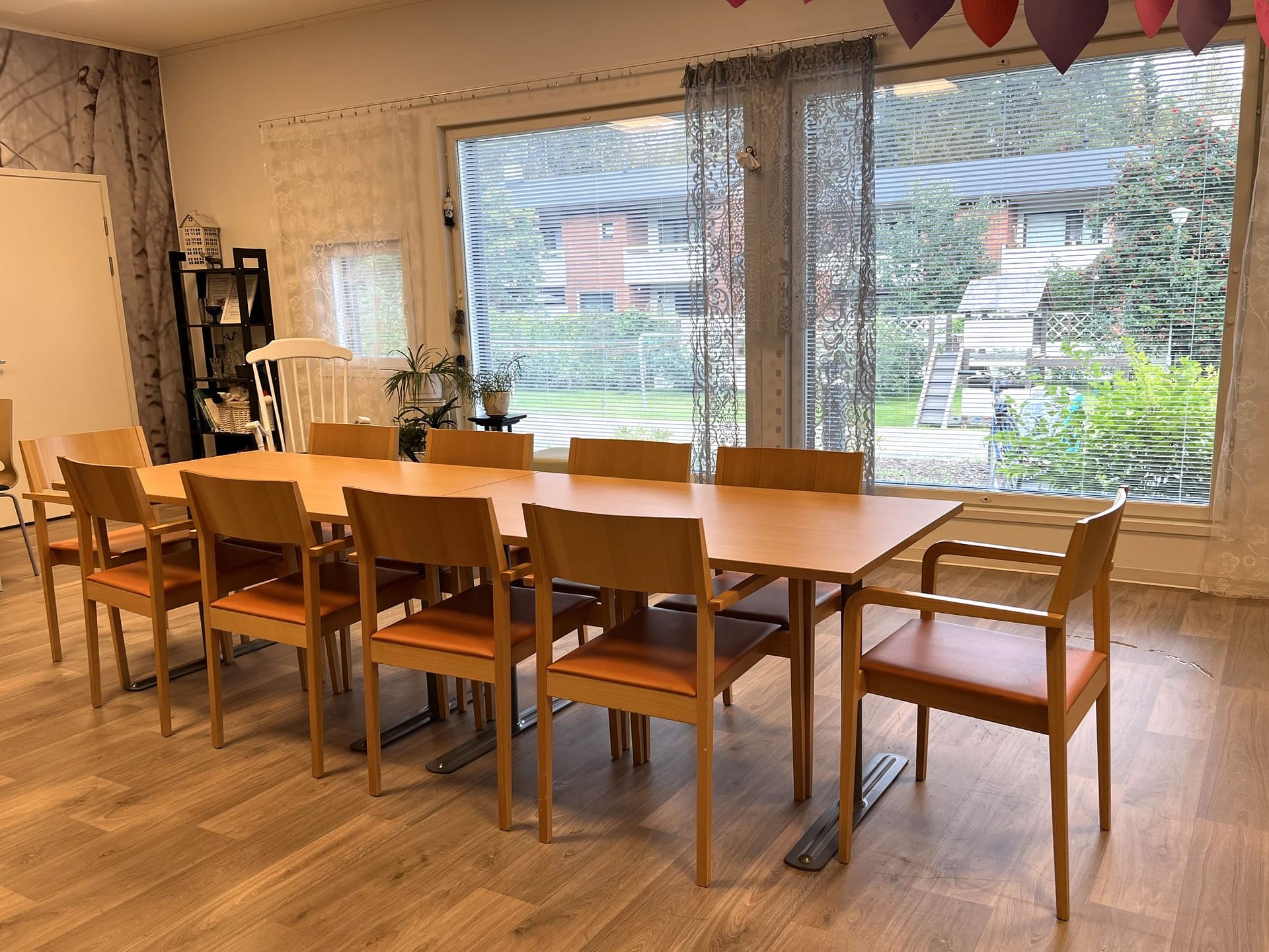 Yhteinen ruokailutila suurten ikkunoiden äärellä