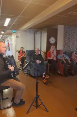 Koivulan asukkaita ja hoitajia nauttimassa musiikista.