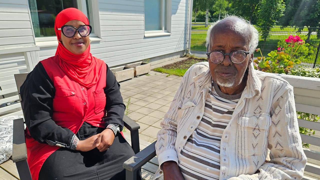 Esperi Koti Metsokankaan lähihoitajaopiskelija Fisan ja asukas Ali istuvat aurinkoisella pihalla.