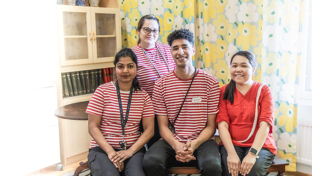 Esperi Hoivakoti Launeessa otettu ryhmäkuva ulkomaalaisista työntekijöistä, jotka hymyileävät kameralle.