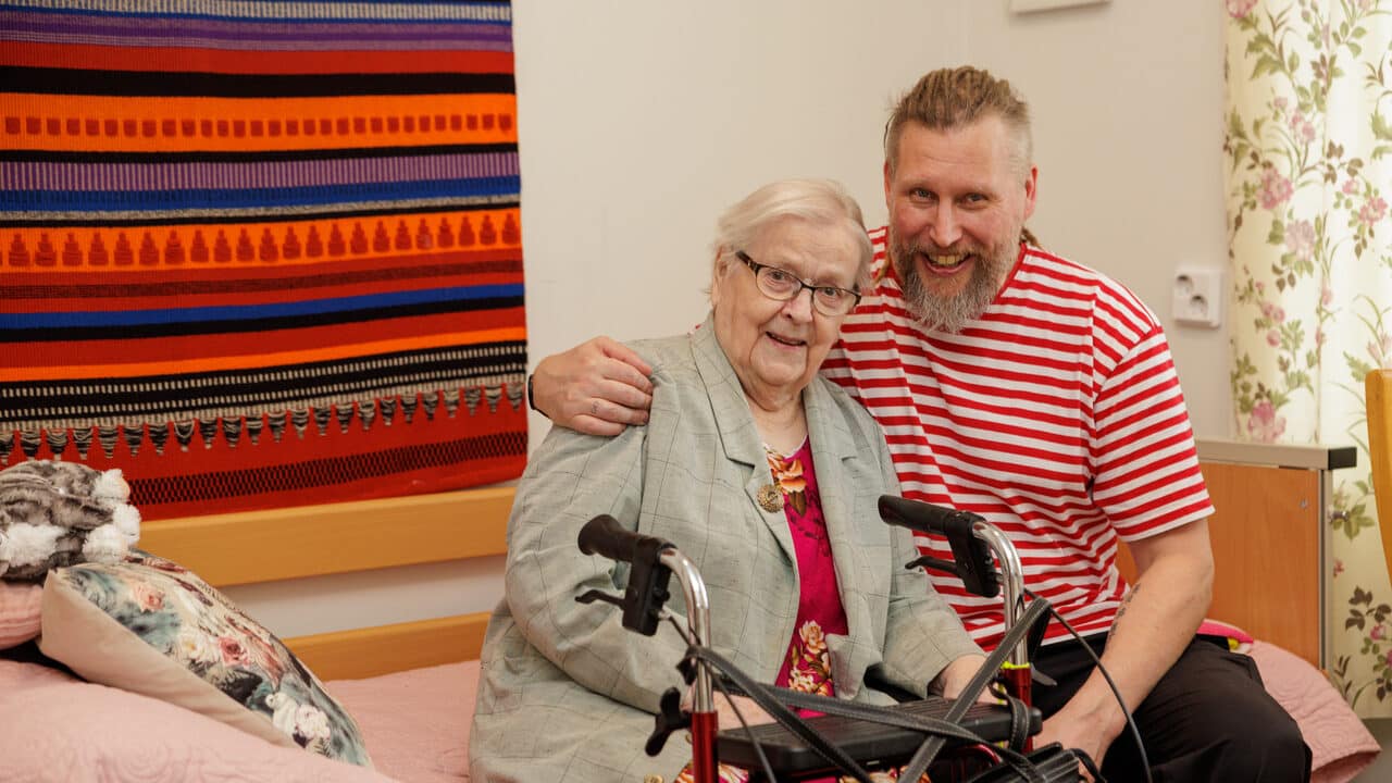 Hoitaja ja asukas hymyilevät yhdessä, välittämistä ja lämpöä Esperin hoivakodin arjessa.