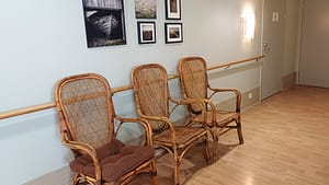 Hoivakodin käytävä, jossa tuoleja ja tauluja.