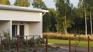 Esperi Hoivakoti Lehtokertun piha-aluetta, jossa näkyy myös rakennuksen pääty ja luontoa.