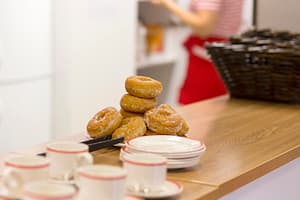 Kahvikuppeja ja herkkuja pöydällä.