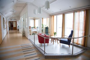 Valoisa käytävä, jossa huonekaluja.