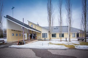 Talon julkisivu, piha-aluetta ja lunta maassa.