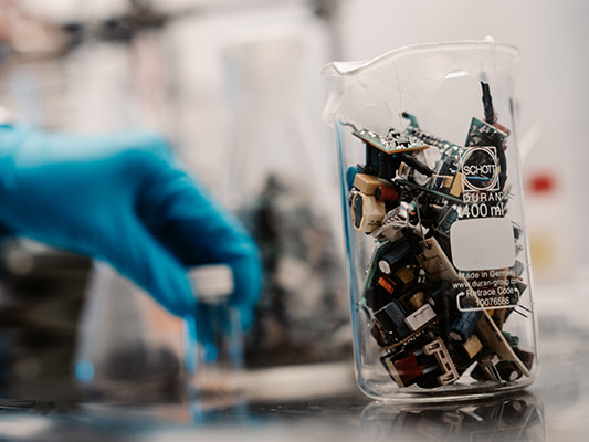 Lasikannun sisällä näkyy tietokoneista purettua elektroniikkaa.