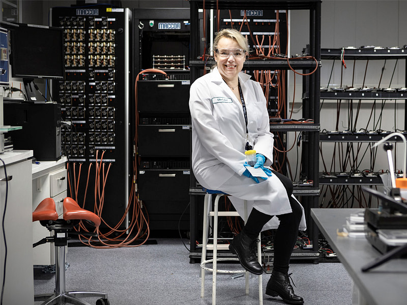Ulla Lassi istuu laboratoriossa.