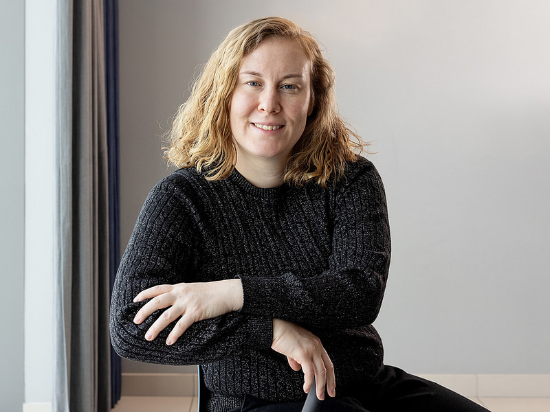 Nanna Myllys istuu tuolilla ja katsoo kohti kameraa