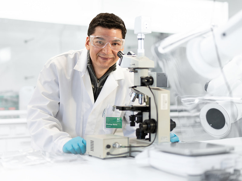 Professori Rodrigo Serna laboratoriossa mikroskoopin takana.